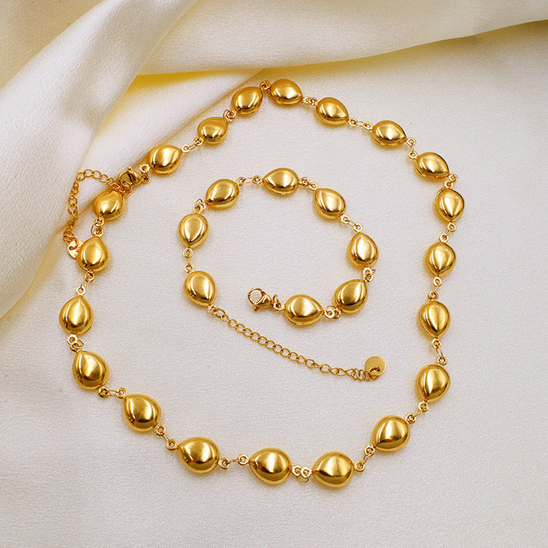 Peb shaped gold necklace and bracelet
